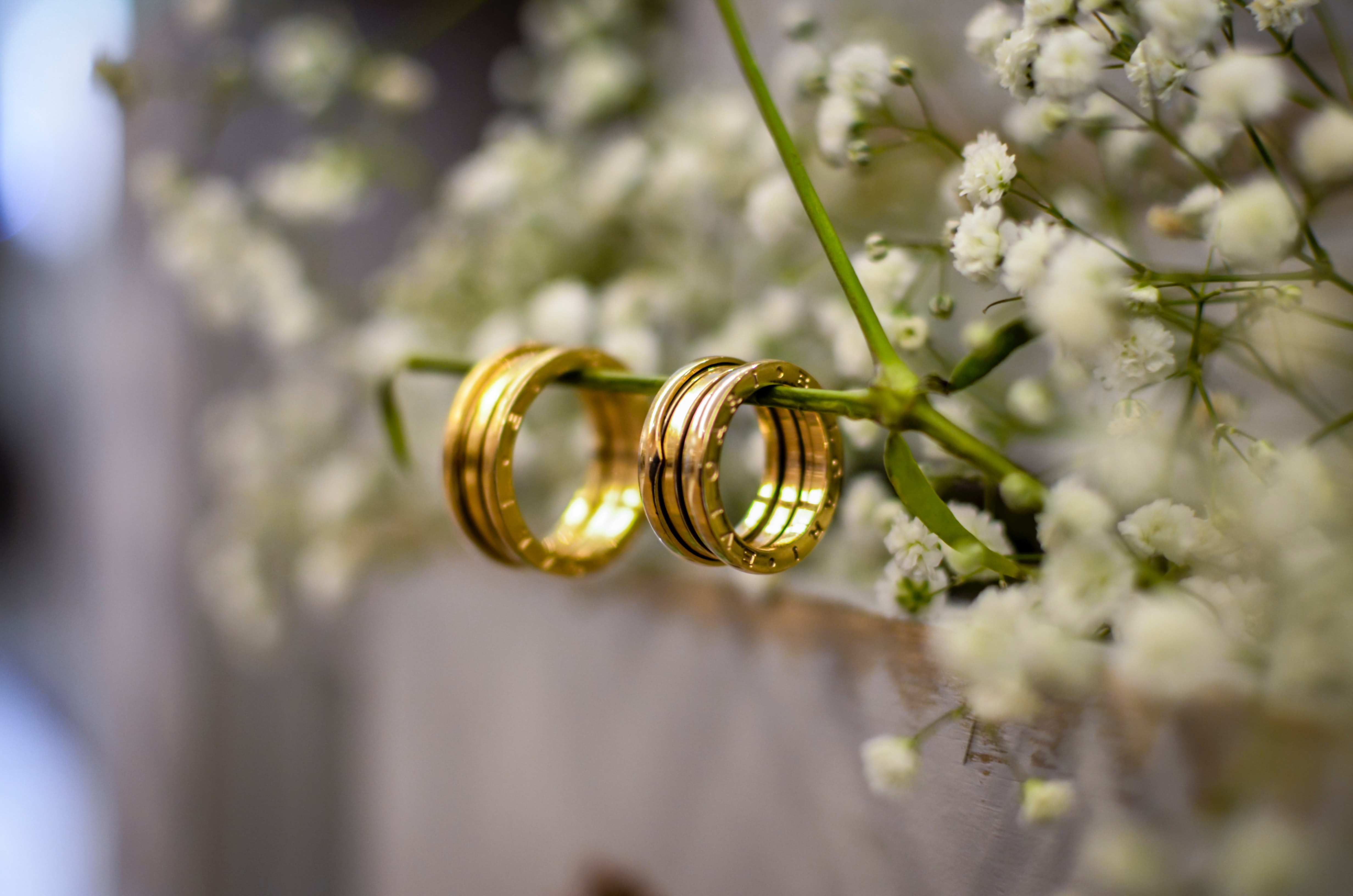 Premium Photo | Golden wedding rings in the center on the white floor with  sparkling background